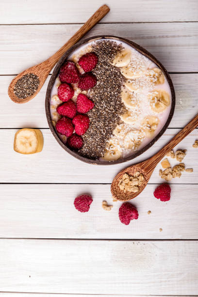 istock Plant based diet concept.Vegan smoothie bowl with chia pudding, berries and granola in a coconut shell on a white wooden background. 1223019454
