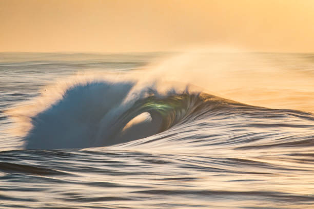 istock Smooth wave breaking in the sea during golden light 1223021328