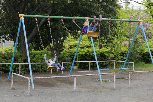 Japanese brother and sister on the swing  (10 years old boy and 5 years old girl)