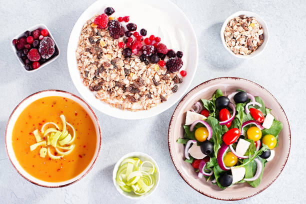 soupe à la crème de carottes, salade grecque, bol de granola avec yaourt sur le dessus de table en béton avec espace de copie. assortiment de plats pour l’alimentation, adapté à l’alimentation en volume et d’autres stratégies nutritionnelles, v - 7652 photos et images de collection