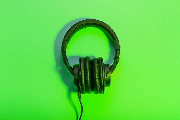istock Black overhead headphones neon background, copy space. Modern technology flat lay with over-ear earphones and cable, modern lifestyle gadget concept 1223022271
