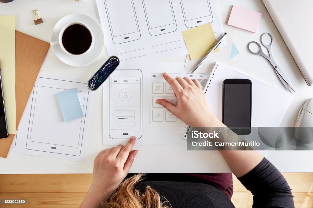 Wireframes. User experience concept Young UX graphic designer planning out the structure of a mobile application. Wireframing stage of a web mobile phone. Top view Web Design Stock Photo
