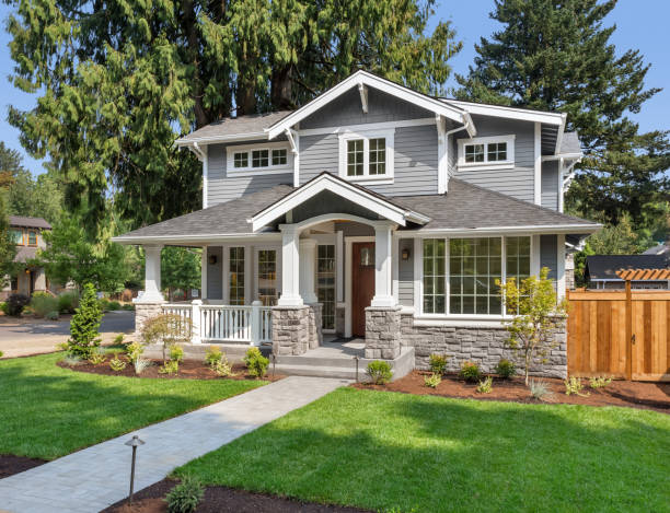 bellissimo esterno di casa di lusso in una luminosa giornata di sole con erba verde e cielo blu. dispone di passerella, portico coperto e maere frontoni e colonne. - green grass lawn front or back yard foto e immagini stock