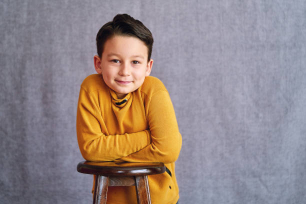 6-7 years old confident cute child portrait on gray background.