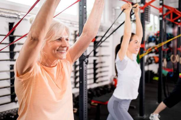 istock Senior people with trainer using resistance band doing exercises at the gym 1223023525