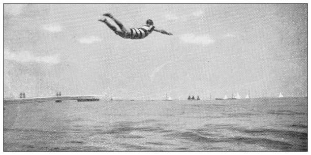 antikes schwarz-weiß-foto von sport, sportlern und freizeitaktivitäten im 19. jahrhundert: springbretttauchen - schwimmen fotos stock-grafiken, -clipart, -cartoons und -symbole