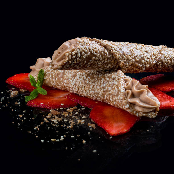 Sesame and caramel tube  with Mascarpone cream on a black background