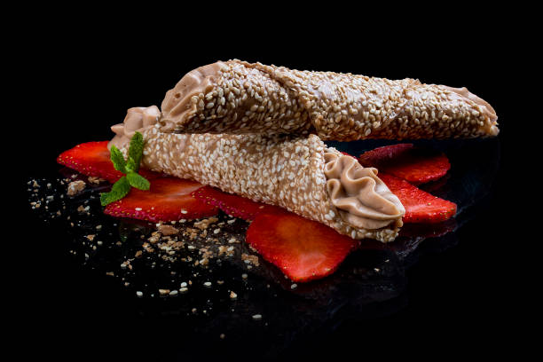 Sesame and caramel tube  with Mascarpone cream on a black background