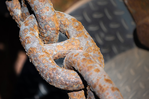 a rusty chain link as part of a thick chain for shipping