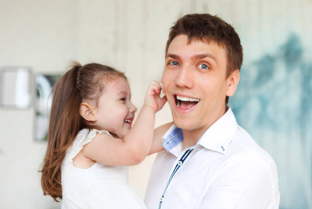 Adorable little daughter embracing father having fun