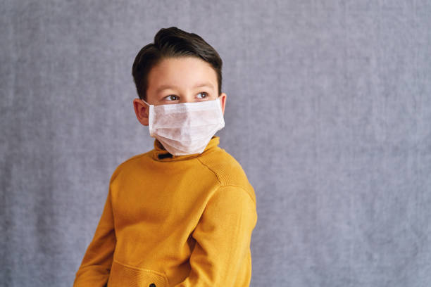 istock 6-7 years old child wearing surgical mask for prevention. 1223027034