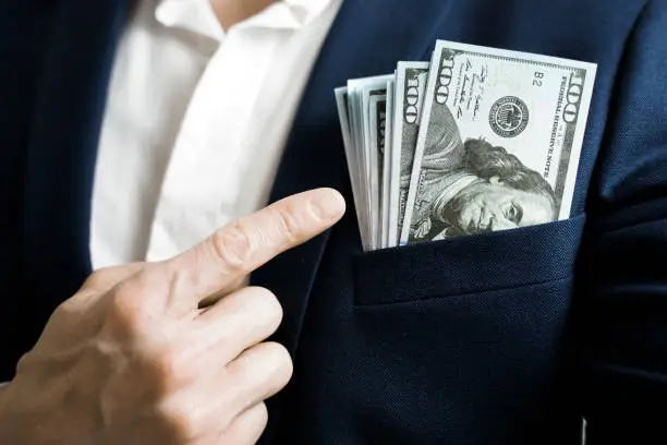 Photo of Money success concept. 100 dollar bills in businessman jacket pocket. Symbol of success and wealth