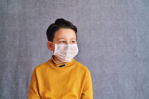 istock 6-7 years old child wearing surgical mask for prevention. 1223027475