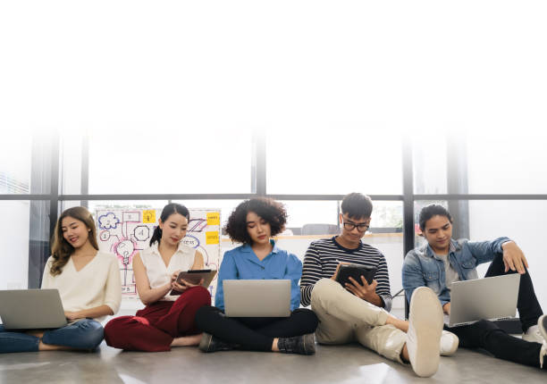 istock Group of young happy Asian creative business people or hipster student using electronic devices tablet and laptop connection together in modern office. Creative lifestyle young people concept 1223028514