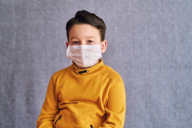 istock 6-7 years old child wearing surgical mask for prevention. 1223029444