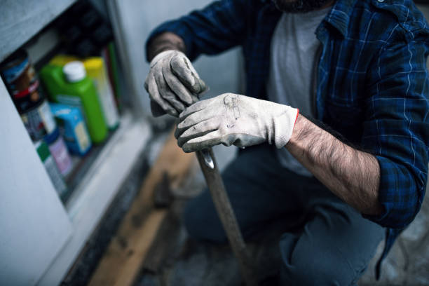 istock Quarantine gardening: a man repairs the hoe before using it in the garden 1223029885