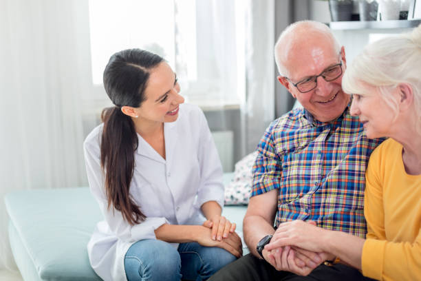 istock Smiling nurse talking with senior couple during home visit 1223030014