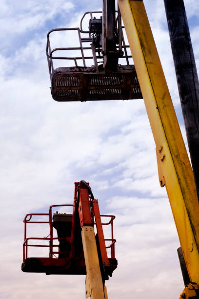 istock Two tall yellow cherry pickers, sky background. 1223031163