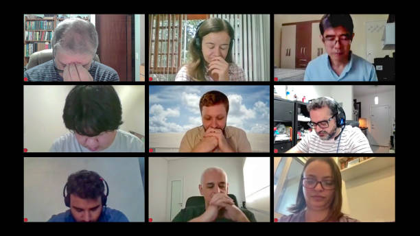 Computer screen lay-out with friends in their homes on a conference call and praying together for the good of all stock photo