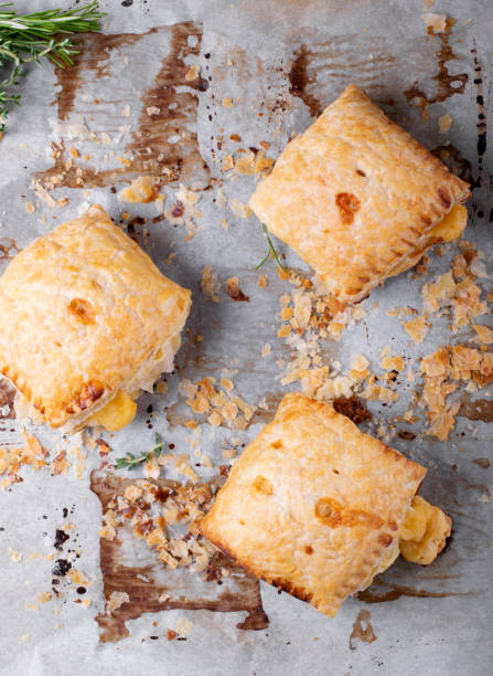 istock Puff pastry buns with cheese on the parchment paper 1223033124