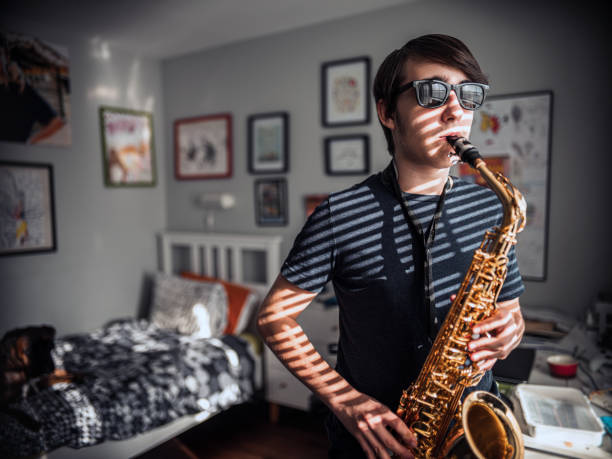 Man playing a saxophone and wearing sunglasses isolated on white background