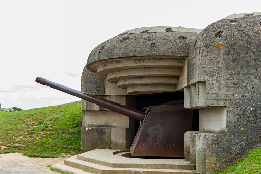 Bomb shelter with German long-range artillery gun from world war 2 in Longues-sur-Mer in Normandy. This site was captured on June 7, 1944 by the British Devonshire Regiment.