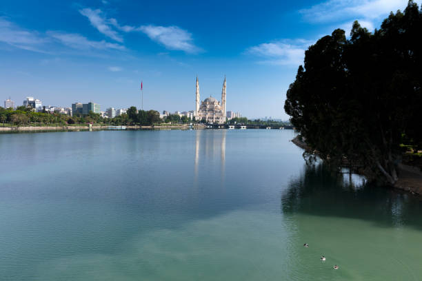 Stone Bridge and Central Mosque Adana, Turkey Mosque has reflections from Seyhan river in sunny day with blue clean sky hultonarchive stock pictures, royalty-free photos & images