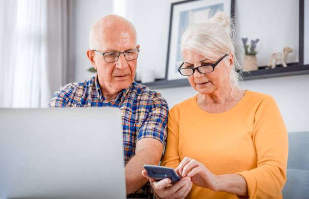 걱정 노인 부부는 집에서 노�트북을 사용하여 청구서를 확인 - home finances calculator finance senior couple 뉴스 사진 이미지