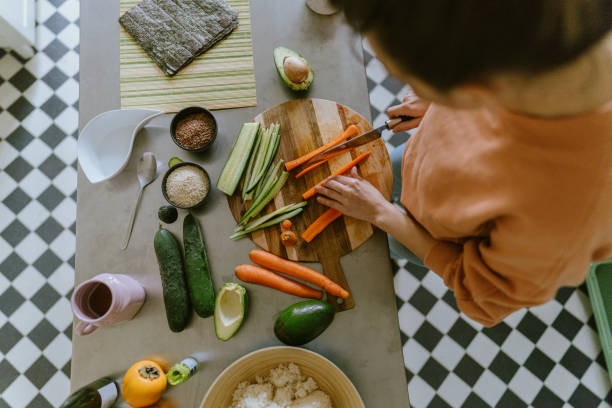istock Young woman cutting vegetables in the kitchen 1223038202