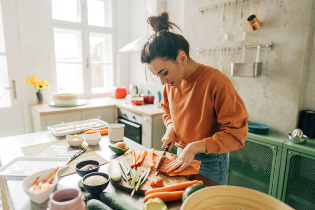 istock Young woman slicing salmon in the kitchen 1223039188
