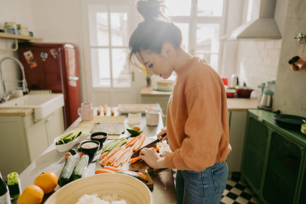 istock Young woman chopping veggies in the kitchen 1223039192