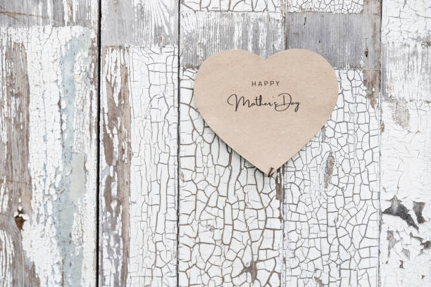 istock Happy Mother's Day written on a heart shaped card on a rustic wall 1223040150