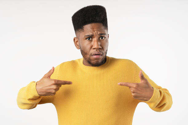 istock Displeased young man points at himself in casual isolated over white background 1223042637