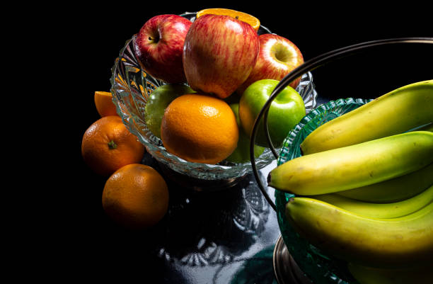 istock Arrangement with fruits on a shiny black surface with black background. 1223043961