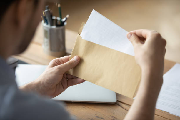 istock Close up businessman holding envelope with blank paper sheet 1223044283