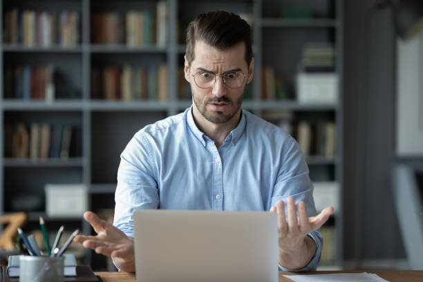 unhappy shocked man having problem with laptop, looking at screen - frustration computer confusion businessman imagens e fotografias de stock