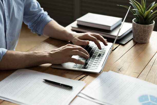 primo piano uomo d'affari con laptop, seduto alla scrivania - dispositivo di input foto e immagini stock