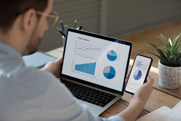 istock Close up businessman working with statistics on laptop and phone 1223044330