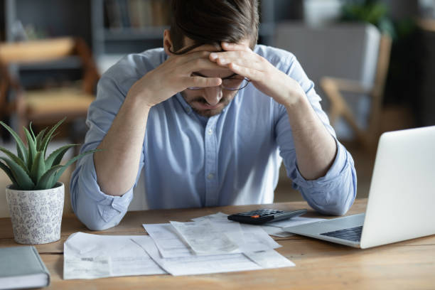 sad depressed man checking bills, anxiety about debt or bankruptcy - ansiedade financeira imagens e fotografias de stock