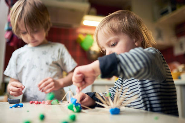 istock Two brothers make three-dimensional figures of plasticine and sticks 1223047823