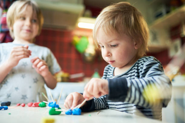 istock Two brothers make three-dimensional figures of plasticine and sticks 1223047942