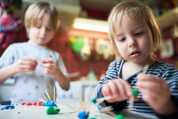 istock Two brothers make three-dimensional figures of plasticine and sticks 1223048000