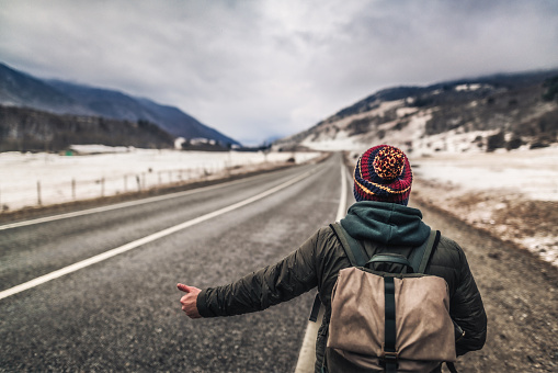 One man, backpacker at the highway and hitchhiking.