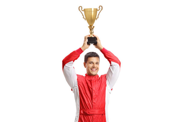 istock Car racer holding a gold trophy cup and smiling 1223049153