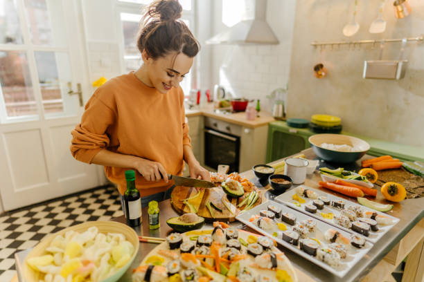 istock Smiling young woman cutting vegetables in the kitchen 1223049684
