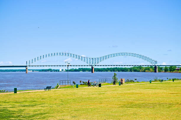 Landscape. People walk and ride bike on the riverside, The Hernando de Soto Bridge on the background. Created in Memphis, TN, 04/26/2020