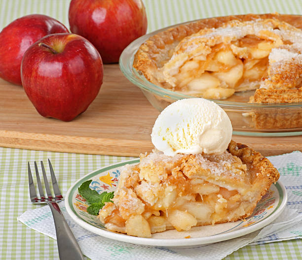 Apple Pie Slice Slice of apple pie on a plate with apples and a pie in the background apple pie and ice cream stock pictures, royalty-free photos & images