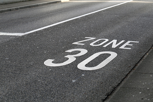 Asphalt driveway in Switzerland with 30km/h speed limit. Speed limit marked to road with text \