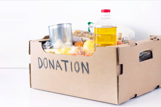 istock Donation. grocery box, help products for those who need it. donation box. cardboard box with the inscription donation with food on a white background. 1223052247