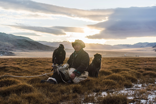 Eagle hunter with dog  in steppe in Mongolia